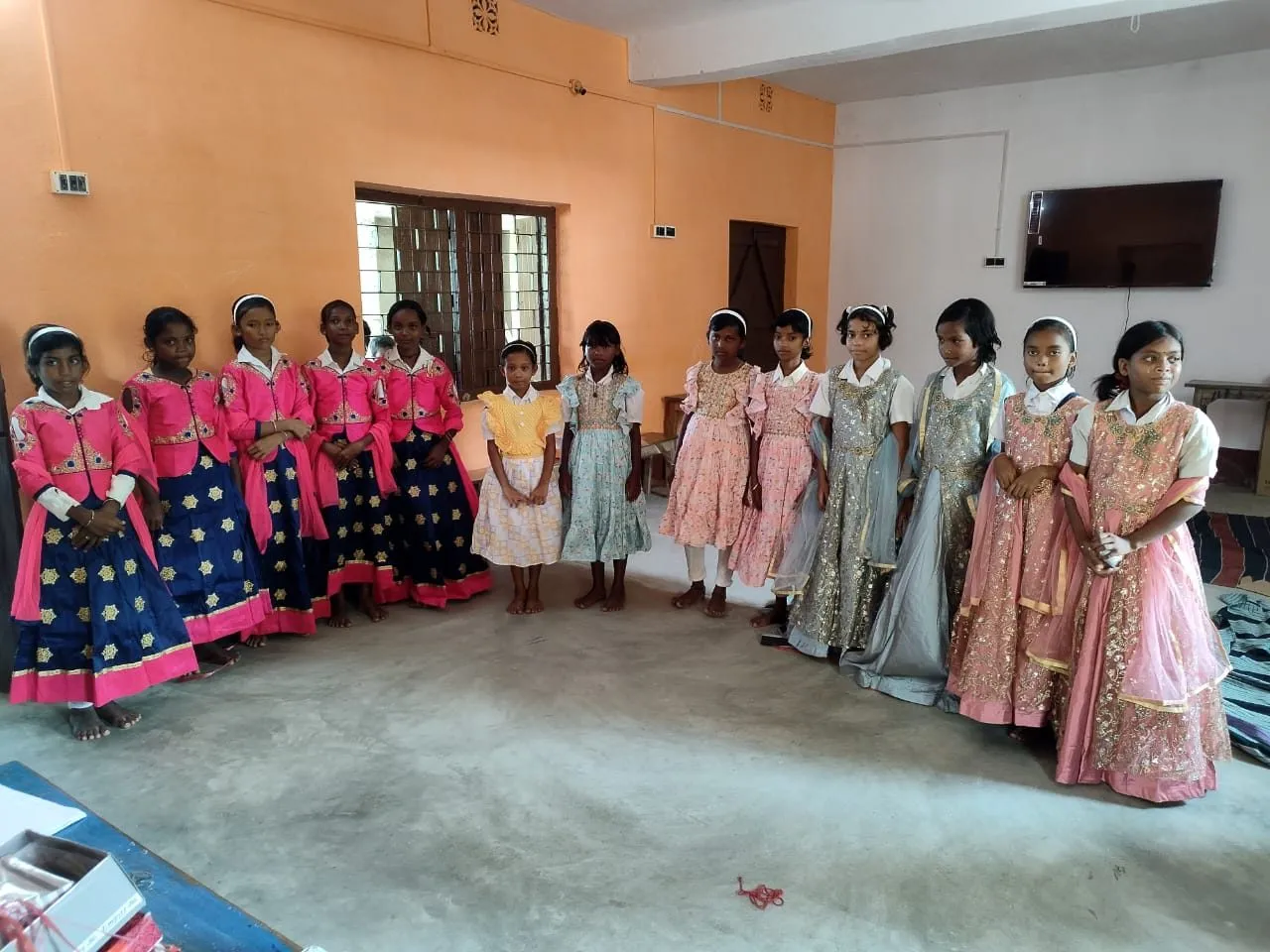 A row of girls smile in their new dresses
