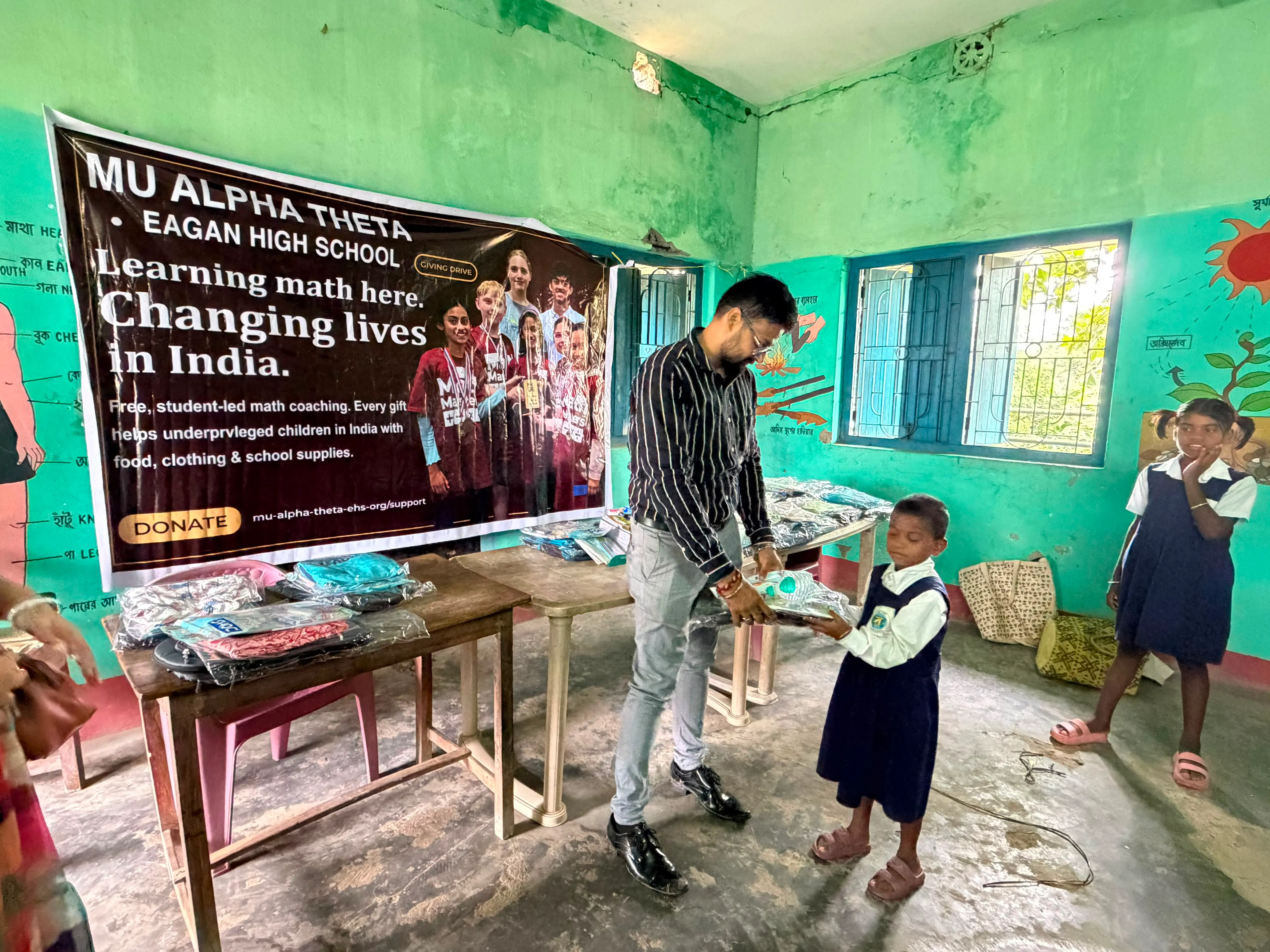 A volunteer hands supplies to a student